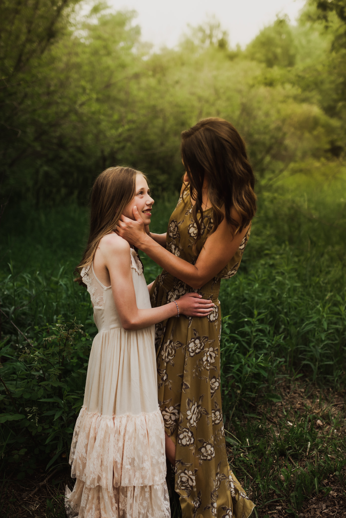 Mother and daughter looking at each other during a sunset photo shoot.