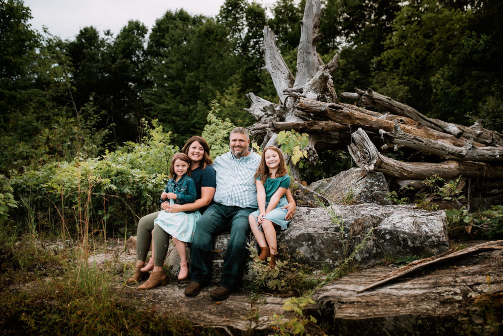 Photo of a family sitting on a rock during a family photo session in Wisconsin